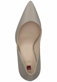 Décolleté in pelle beige a punta con una texture liscia. L'interno presenta una leggera fodera e un piccolo accento quadrato rosso. Design elegante e raffinato.