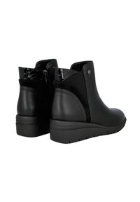 Botas negras hasta el tobillo hechas de cuero y ante, con un acento texturizado negro, puntera redondeada y una suela de cuña baja y texturizada.