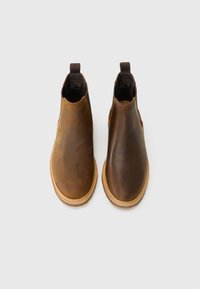 Brown leather ankle boots with a smooth finish, elastic side panels, and a rubber sole. Each boot features a contrasting color at the toe.