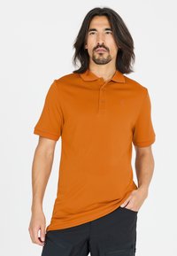 Kortärmad polo i klargul tyg, med krage, tre knappar och en liten logotyp på bröstet.