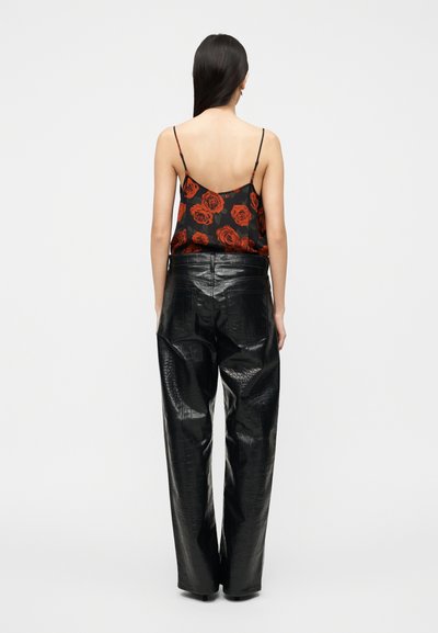Μαύρο παντελόνι με ανάγλυφο μοτίβο κροκό, με ψηλή μέση και άνετη εφαρμογή, συνδυασμένο με διάφανο μαύρο καμησόλ με σχέδιο κόκκινου τριαντάφυλλου.