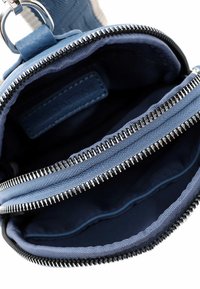 Blue fabric wallet with two zippered compartments. Smooth texture, silver metal zippers, and a soft lining. Interior includes a small leather tag.