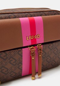 Braune Kunstledertasche mit einem pinken und roten Streifenmuster. Goldene Beschläge mit zwei Reißverschluss-Schiebern und goldener "LIU•JO"-Logo.