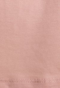 Ljust rosa bomullstyg med en fin ribbad textur och en rak fåll med enkel sömnad längs botten.