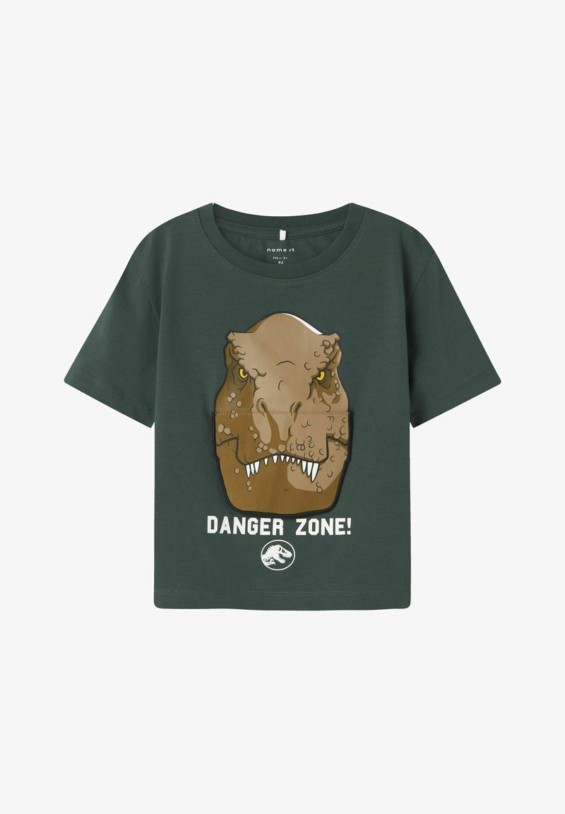 Camiseta de algodón verde con un gráfico de dinosaurio, que presenta la cabeza de un T-rex marrón y texto blanco que dice "¡ZONA PELIGROSA!" en la parte inferior.