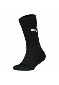 Sorte bomuldsblandede sokker med ribbet tekstur, ankellængde, og et hvidt Puma-logo trykt på siden.