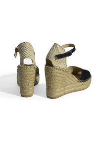 Sandales compensées avec un capuchon de orteil en suède bleu marine, un dessus en chaîne naturelle, une bride à la cheville réglable et un talon de jute tressé.