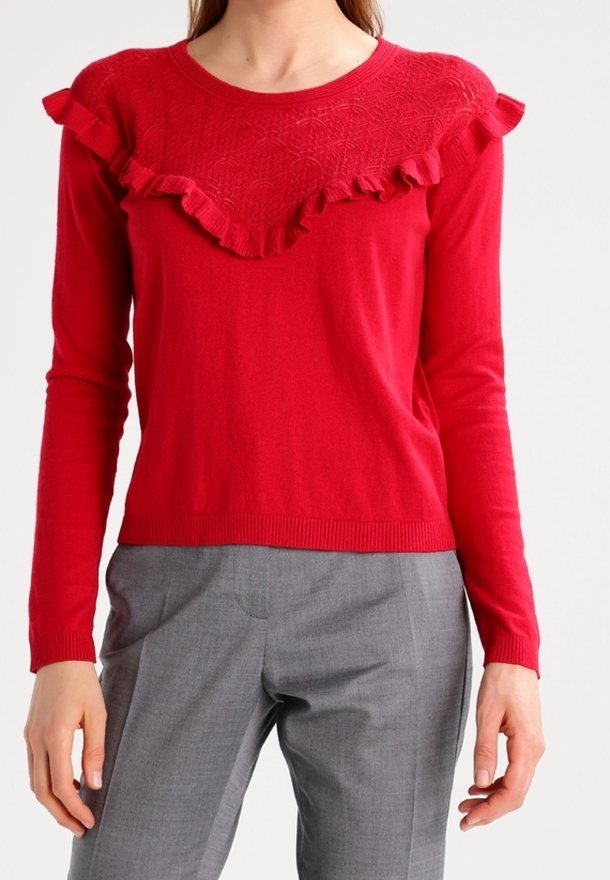 Rode trui met lange mouwen, met een gestructureerde gerimpelde kraag en geribbelde manchetten, gecombineerd met grijze, op maat gemaakte broek. Gladde stofafwerking.