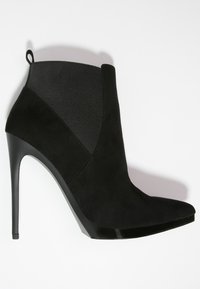 Stivale alla caviglia in suede nero con punta a punta, alto tacco a spillo e lati elasticizzati per una facile vestibilità. Texture liscia con dettagli lucidi.