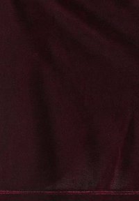 Dark maroon fabric with visible soft folds and a stitched hem along the bottom edge.