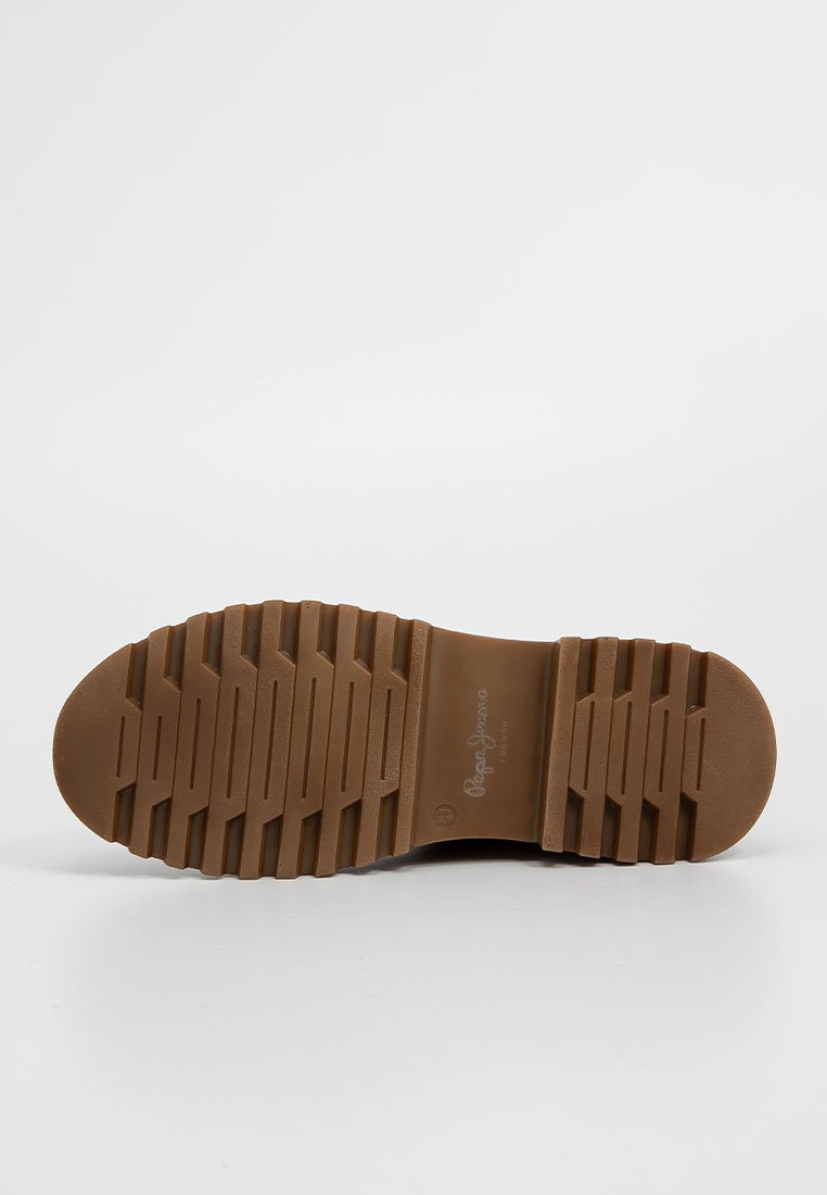 Suela de goma marrón con un patrón de textura y bordes suaves. Presenta un logo de la marca cerca del talón; diseñada para ofrecer tracción y durabilidad.