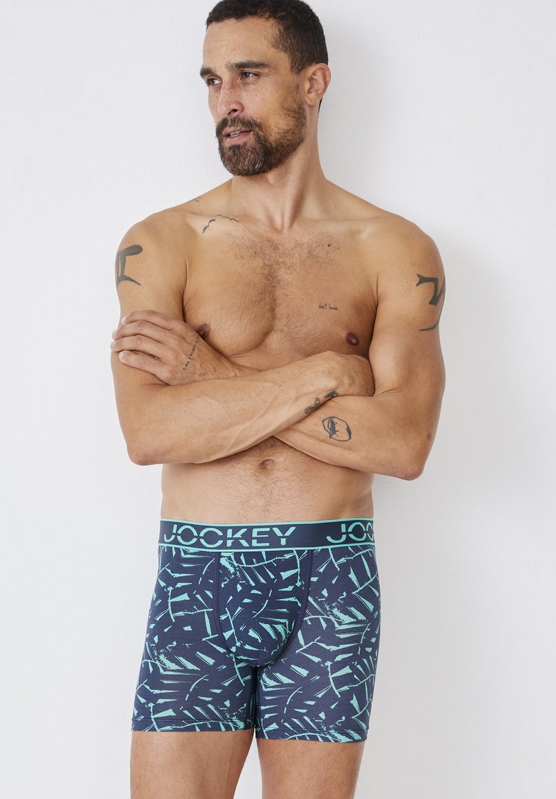 Jockey boxershorts met een donkerblauw en mintgroen bladrandpatroon. Elastische tailleband met het logo "JOCKEY". Zachte stof met een aansluitend ontwerp.
