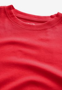 T-shirt rosso in cotone con scollatura a girocollo a costine. Tessuto morbido, stoffa liscia e senza motivi o accenti visibili.