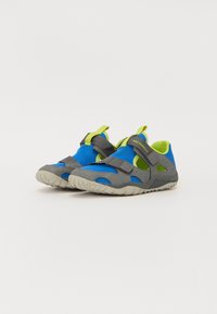 Zapatillas deportivas en azul y gris con malla transpirable, correas de Velcro y suelas de goma. Presentan acentos en verde brillante y recortes para ventilación.