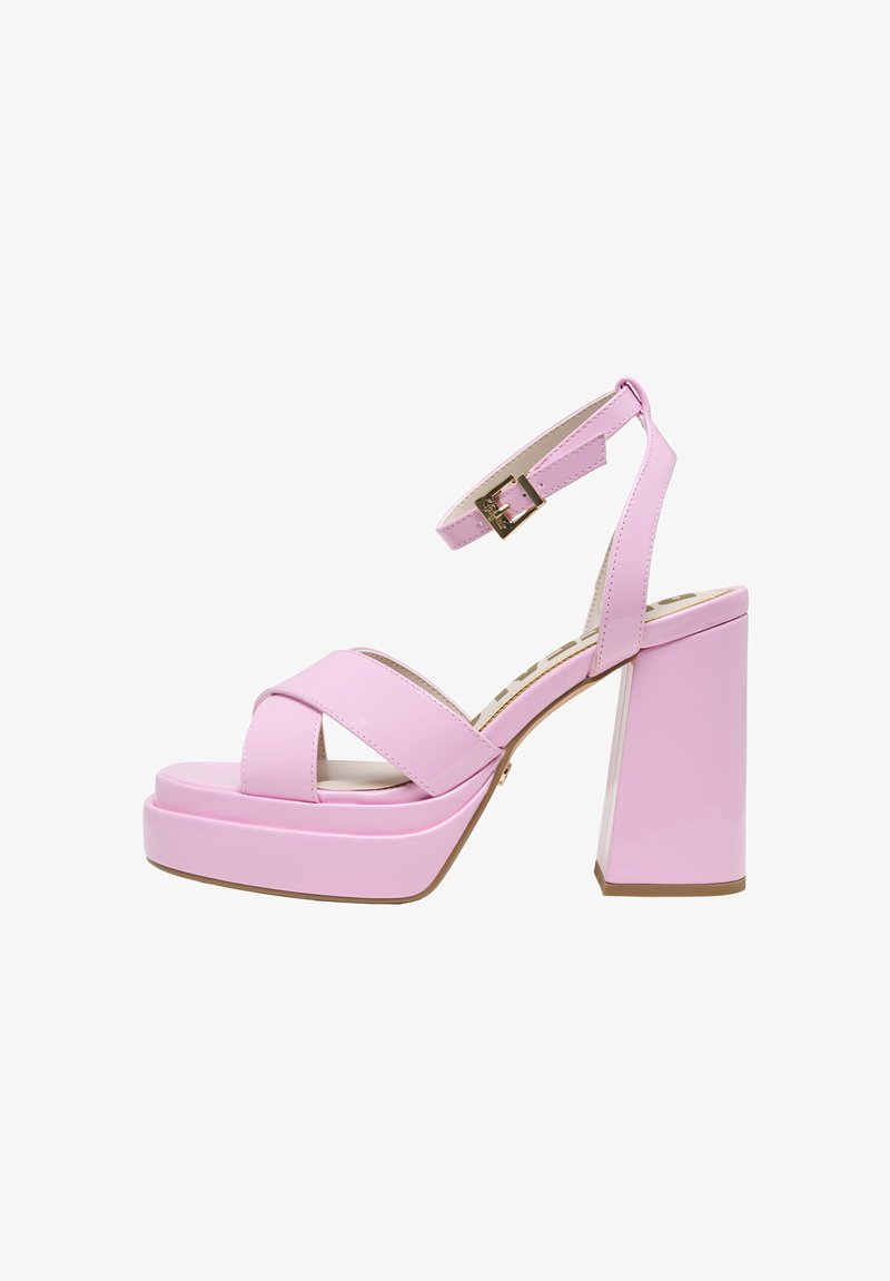 Różowe sandały na platformie z lakierowanej skóry z szerokim, skośnym obcasem typu blok, paskami krzyżującymi się na stopie oraz regulowanym paskiem przy kostce z klamerką.