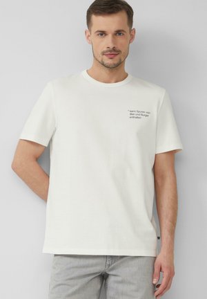 Weißes Baumwoll-T-Shirt mit kurzen Ärmeln, Rundhalsausschnitt und schwarzem Text auf der linken Brustseite, mit einer humorvollen Botschaft über Zutaten.
