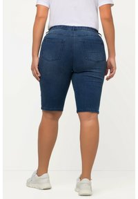 Bermudas en denim, bleu foncé, en tissu extensible. Taille élastique, deux poches arrière, longueur genou, avec une texture lisse.