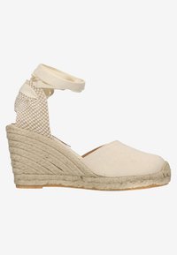 Beige canvas espadrille met een geweven jute zool, voorzien van een wig-hak en een textuur enkelband van zacht stof.