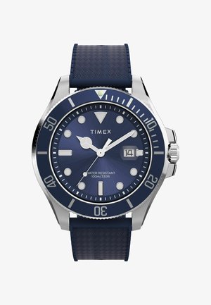 Orologio da polso Timex con cinturino in gomma testurizzata blu, cassa in acciaio inossidabile, quadrante blu, lancette argento e marcatori delle ore bianchi. Resistente all'acqua fino a 100 metri.