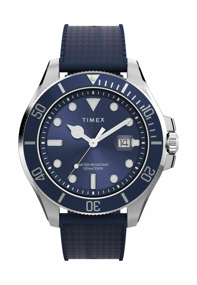 Montre Timex avec un bracelet en caoutchouc texturé bleu marine, boîtier en acier inoxydable, cadran bleu, aiguilles en argent et index horaires blancs. Étanche jusqu'à 100 m.