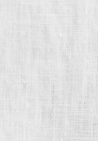 Texture de tissu blanc tissé avec un motif en grille visible et des fibres lâches, créant une apparence douce et naturelle.