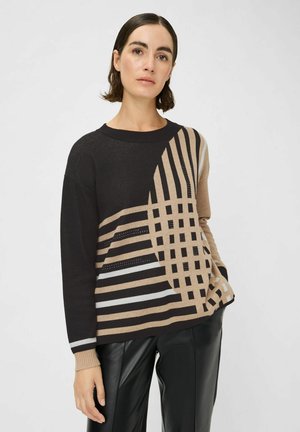 Pull en tricot avec un motif géométrique en noir, beige et blanc, avec des rayures horizontales et verticales, et un col rond.