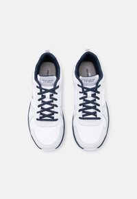 Zapatillas deportivas blancas con acentos en azul marino, parte superior de malla y sintético, diseño con cordones, cuello acolchado y plantilla acolchada.