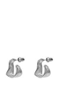 Silberne Ohrringe aus Metall mit einer fließenden, wellenartigen Form, glänzender Oberfläche und Steckverschluss. Das Design ist zeitgenössisch und skulptural.