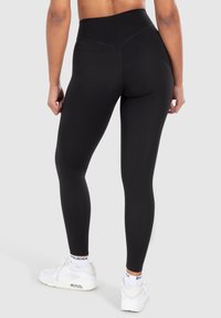 Leggings neri a vita alta realizzati in materiale elasticizzato con una texture liscia, caratterizzati da un design senza cuciture e una fascia larga in vita per il massimo comfort.