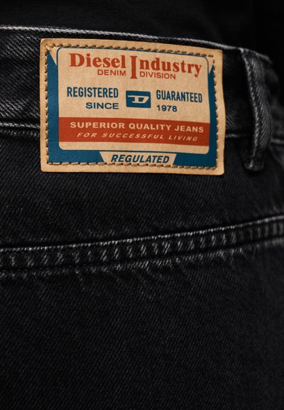 Étiquette en cuir sur un jean en denim noir avec la marque "Diesel Industry Denim Division" et un texte sur la qualité et l'enregistrement depuis 1978.