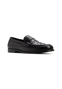 Zwarte leren loafers met decoratieve studs op de bovenkant, een platte zool en een ronde neus. Gladde textuur met een gepolijste afwerking.