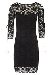 Robe en dentelle noire à manches longues, ornée de motifs floraux, avec des découpes aux épaules et des liens aux poignets. Détail d'ourlet festonné.