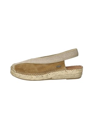 Tan suede espadrille with beige elastic band and woven jute sole. Features a rounded toe and slip-on design. Textured material contrast.