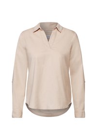 Blusa de manga larga color beige claro con escote en V, ligero brillo y detalles de botones en las mangas enrolladas. El dobladillo redondeado ofrece un ajuste relajado.