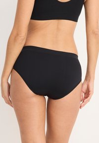 Briefs neri a vita alta realizzati in un tessuto morbido ed elastico. Presentano una cintura liscia e bordi senza cuciture per garantire comfort e vestibilità.