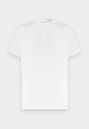 Απλό λευκό κοντομάνικο T-shirt με στρογγυλή λαιμόκοψη και διακριτική ριμπ υφή, απεικονίζεται σε ουδέτερο γκρι φόντο.