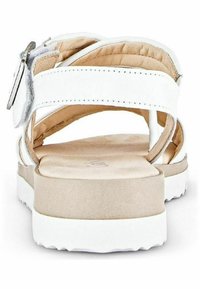 Sandales en cuir blanc avec une sangle à la cheville à boucle, semelle intérieure beige douce, semelle en caoutchouc légère et design ouvert pour respirabilité.