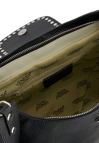 Czarna skórzana torebka z klapką ozdobioną ćwiekami, zapięciem na zamek i beżową podszewką z powtarzającym się nadrukiem "VENEZIA".