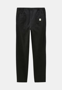 Pantalons noirs avec une taille élastique, deux poches arrière et un petit logo cousu. Fabriqués en tissu durable avec une texture lisse.