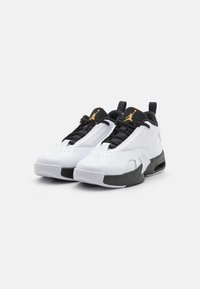 Białe i czarne buty sportowe o błyszczącym wykończeniu, z teksturowanymi panelami z siateczki, wyściełanym kołnierzem, czarnymi sznurowadłami oraz złotym akcentem logo.