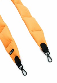 Gewatteerde oranje band met een doorgestikt patroon, voorzien van zwarte leren accenten en stevige metalen clips aan elk uiteinde voor bevestiging.