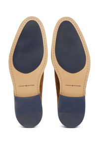 Semelles de chaussures en cuir avec une tige beige clair et un talon en caoutchouc bleu foncé. Détails cousus le long du bord, logo imprimé sur la semelle intérieure.