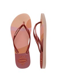 Flip-flops Havaianas cu o talpă din cauciuc texturat în nuanțe de roz și terracotta. Bretele subțiri, metalice, de culoare maro, cu detaliu de logo.