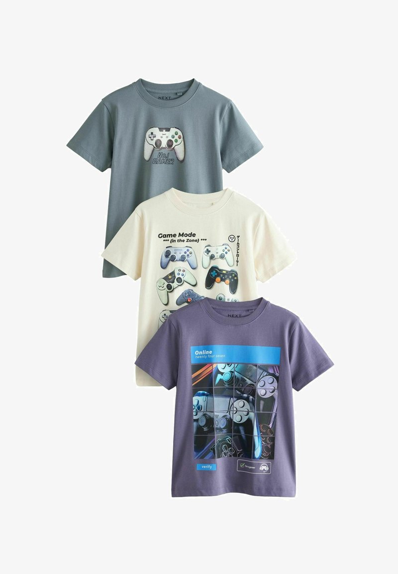 Trys medvilniniai marškinėliai: pilki su žaidimų valdymo pultelių grafika, grietinėlės spalvos su pulteliais ir tekstu, purpuriniai su koliažu ir mėlynu akcentu.