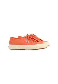 Zapatillas de lona naranjas con puntera redonda, diseño de cordones y suela de goma crema en contraste. Presenta ojales plateados y logo de la marca.