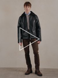 Must nahast jakk karvaga kraega, all hall kootud kampsun, pruunid püksid ja pruunid paeltega saapad. Lihtne disain ja funktsionaalsed detailid.