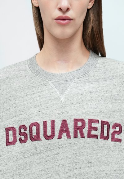 Pelēka sporta džemperis ar lielu bordo krāsas izšūtu "DSQUARED2" logotipu, fakturētu audumu un apaļu kakla izgriezumu ar šuvju detaļām.
