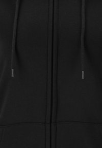 Hoodie zippé noir en tissu doux, doté d'une fermeture éclair à l'avant, de deux poches et de cordons de serrage ajustables sur la capuche.