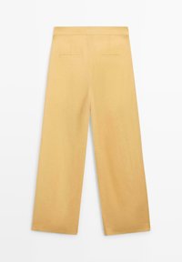 Pantalon jaune à jambes larges avec poches arrière plates et taille lisse, présenté à plat sur un fond blanc.