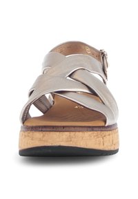 Metallic silver cross-strap sandal with cork sole, textured footbed, and adjustable buckle. Flat heel and casual design.